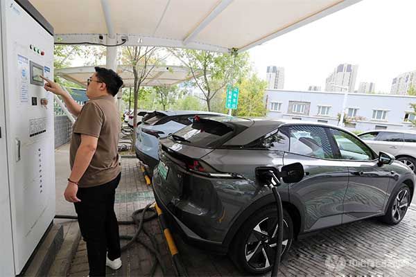 5月8日，车主在乌鲁木齐益民大厦停车场给新能源汽车充电。